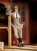 A man in vintage clothing leans against a wooden structure. Produktbild-Vorschau