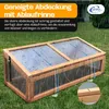A wooden cold frame with a transparent, sloped lid is shown in the rain on a grassy lawn. Blue arrows indicate water runoff. Produktbild-Vorschau