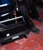 A person is working on a car with a tool trolley. Voir les images du produit