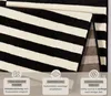 A close-up of a black and white striped rug, with informational overlays at the bottom. Anteprima dell’immagine prodotto