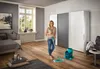 A woman is cleaning a room with a mop and bucket. Produktbild-Vorschau