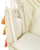 A close-up view of a hanging chair, showing its fabric, tassels, and a pocket. Produktbild-Vorschau