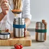 A person is filling a food flask with soup from a ladle, with another food flask and tomatoes on a wooden board. Náhled obrázku produktu