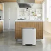 A modern kitchen with a white Brabantia Bo trash can in the foreground, placed in front of a wooden kitchen island. Náhľad obrázku produktu