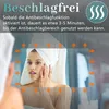 A woman is looking in a mirror, and the mirror has a graphic overlay indicating an anti-fog feature. Produktbild-Vorschau