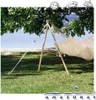 A hammock stand with a white hammock is set up on a grassy lawn near a body of water, with trees providing shade. Podgląd zdjęcia produktu