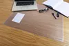A desk setup with a laptop, glasses, pen, notebook, and a transparent desk mat. Produktbild-Vorschau