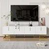 A white TV stand with gold legs is shown in a living room setting, with a large TV mounted above it. Produktbild-Vorschau