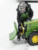 A child is playing with a toy tractor with a snow plow attachment in the snow. Produktbild-Vorschau