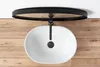 A white oval basin sink with a black faucet is mounted on a wooden surface, with a black circular shelf above it. Anteprima dell’immagine prodotto
