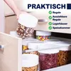 A hand is reaching into a kitchen drawer to pull out a clear plastic container filled with cereal. Several other containers filled with various food items are visible in the drawer. Produktbild-Vorschau