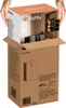 Hands holding the top of a product box, which is being placed into a larger shipping box. Anteprima dell’immagine prodotto