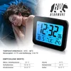 A woman sleeping next to a digital alarm clock displaying the time and temperature. Podgląd zdjęcia produktu