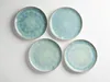 Four blue and green ceramic plates are arranged on a white background. Produktbild-Vorschau