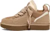 A side view of a beige UGG sneaker with a thick brown sole and white fur lining. Náhľad obrázku produktu