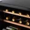 A close-up shot of a wine cooler with shelves filled with wine bottles. Produktbild-Vorschau