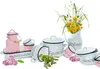 A collection of enamel kitchenware, including pots, a milk jug, and cups, arranged with a bouquet of wildflowers. Voir les images du produit