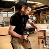 A man is using a cordless drill in a workshop. Produktbild-Vorschau