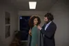 A man is helping a woman put on a coat in a hallway. Produktbild-Vorschau