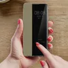 A person's hands are holding a smartphone with a flip case, showing the time and date on the screen. Produktbild-Vorschau
