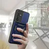 A hand holding a blue phone case with a ring holder, with a blurred indoor background. Produktbild-Vorschau
