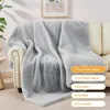 A light gray fluffy blanket draped over a sofa and armchair, with a framed picture on the wall in the background. Produktbild-Vorschau