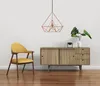 A yellow armchair and a wooden cabinet with a plant on top, against a white wall. Produktbild-Vorschau