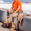A construction worker sitting on a ledge on a rooftop. Produktbild-Vorschau