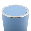 Close-up of the top of a pastel blue trash can with a silver rim. Voir les images du produit