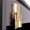 A close-up of a metal bracket attached to a dark wood surface. Produktbild-Vorschau