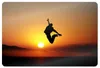 A person jumping in the air against a sunset. Produktbild-Vorschau