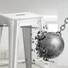 A silver metal bar stool is being struck by a wrecking ball, causing it to shatter. Náhľad obrázku produktu