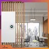 An office environment with a large window overlooking a city skyline, featuring desks, chairs, and a white device mounted on a wooden partition. Podgląd zdjęcia produktu