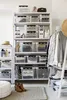 A well-organized closet or storage area with shelves filled with clear storage boxes, clothing, and accessories. Produktbild-Vorschau