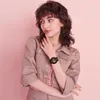 A young woman is posing with a pink background, wearing a watch. Anteprima dell’immagine prodotto