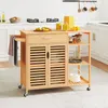 A wooden kitchen cart with wheels, a drawer, slatted cabinet doors, and open shelves, placed in a kitchen setting. Podgląd zdjęcia produktu