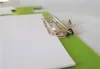 A close-up shot of a green clipboard with a white sheet of paper clipped to it. Produktbild-Vorschau