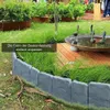 Graue Steinoptik-Gartenkante, installiert in einer geschwungenen Form um eine Grasfläche neben einer Holzterrasse und Vogeltränke Náhľad obrázku produktu