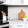 A kitchen counter with a backsplash, cabinets, and appliances. Náhľad obrázku produktu