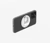 A dark-colored smartphone with a white and silver accessory attached to its back, shown against a white background. Produktbild-Vorschau