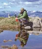 A man is filtering water from a mountain stream with a portable water filter. Anteprima dell’immagine prodotto