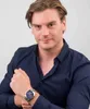 A man wearing a dark blue shirt and a silver watch. Produktbild-Vorschau