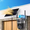 A solar-powered security camera with dual lenses and antennas is mounted on a wall next to a solar panel, with a wooden garage door in the background. Náhľad obrázku produktu
