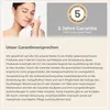 A woman is shown gently touching her face with a white towel, next to a graphic promoting a 5-year warranty. Produktbild-Vorschau