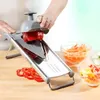 A person is using a vegetable slicer to cut a red bell pepper. Sliced vegetables are in bowls in the background. Produktbild-Vorschau