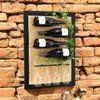 A black metal wine rack with four wine bottles and wine glasses, mounted on a brick wall. Produktbild-Vorschau