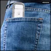 A white electronic device is tucked into the back pocket of a pair of blue jeans. Náhľad obrázku produktu