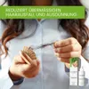 A person holding a brush with hair and two product bottles. Produktbild-Vorschau