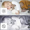 A baby sleeping with a stuffed animal, shown in both color and black and white. Produktbild-Vorschau