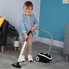 A young child is playing with a toy vacuum cleaner in a room. Náhled obrázku produktu